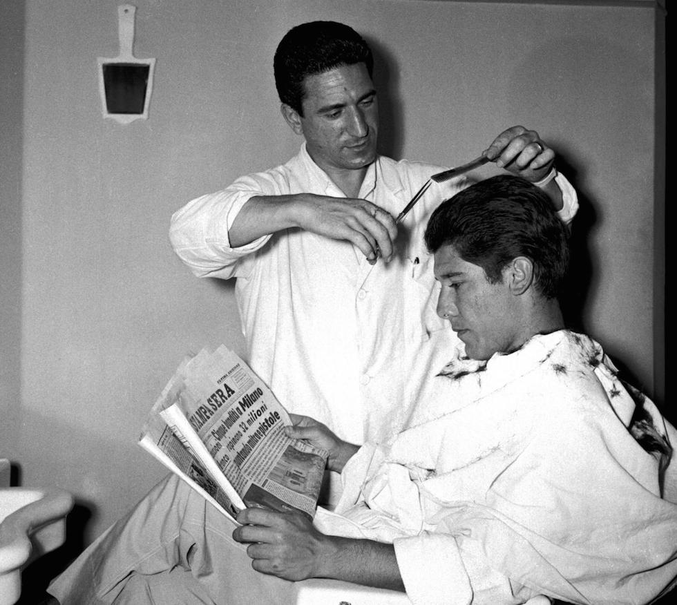 A man getting a haircut at a barbershop in 1957