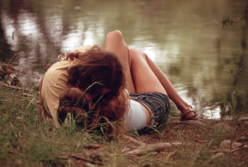 A teenage couple embracing on the grassy bank of the Frio River in Texas in May 1973