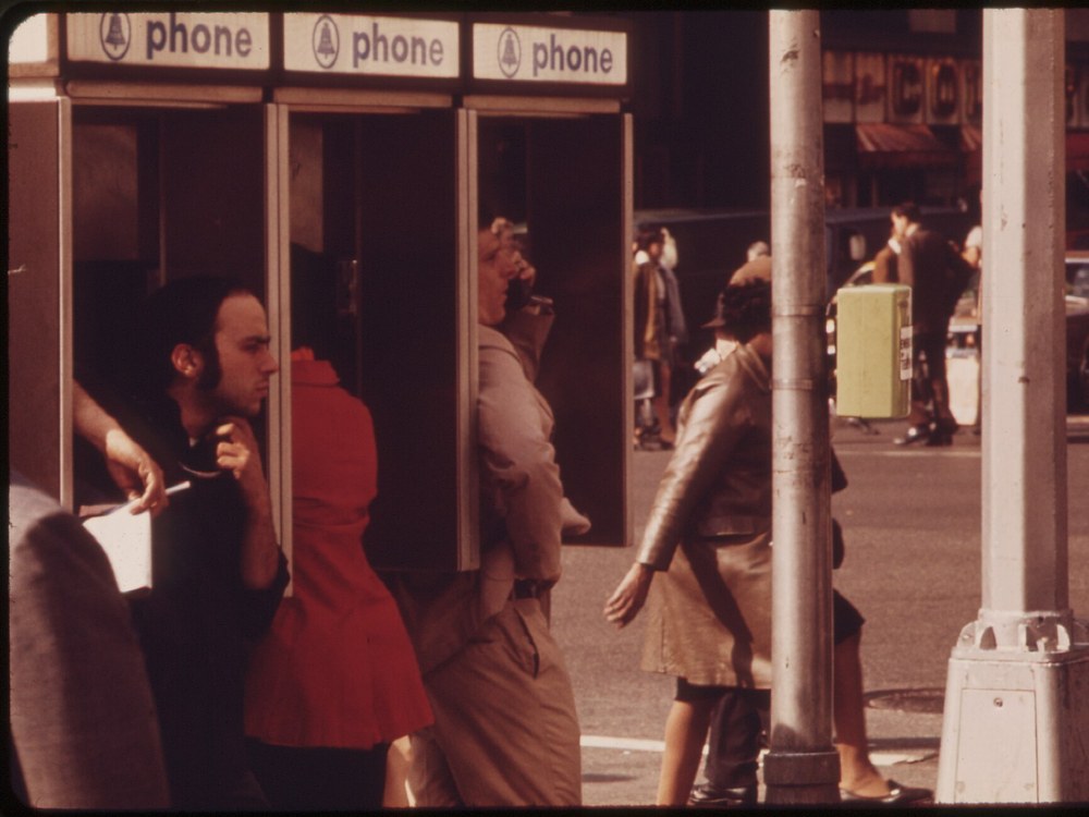 Three outdoor Bell System telephone booths in use on a busy Manhattan sidewalk in 1973