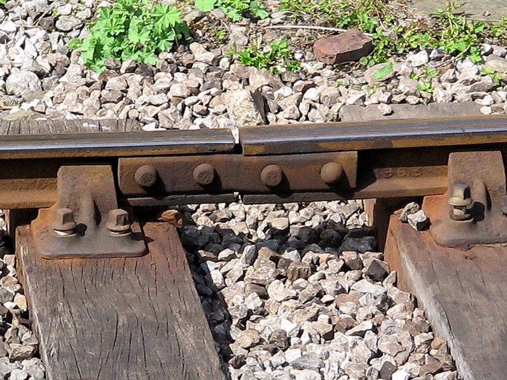 Two rail sections joined end to end by a bolted steel fishplate