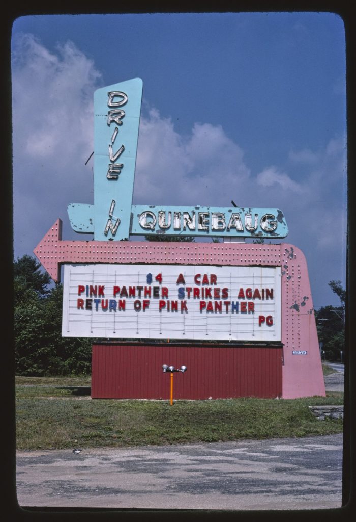 A pink arrow-shaped drive-in sign under a turquoise Quinebaug Drive In sign, its marquee reading $4 a car, Pink Panther Strikes Again, Return of Pink Panther, PG.