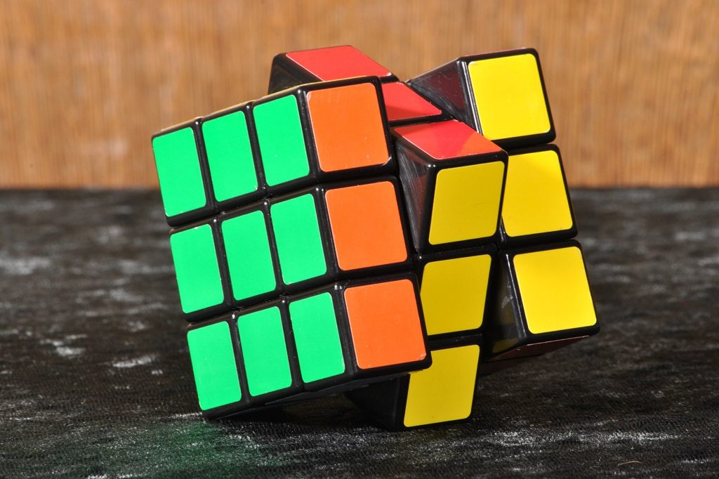 A classic Rubik's Cube with green, orange, red and yellow stickers, its top layers twisted partway