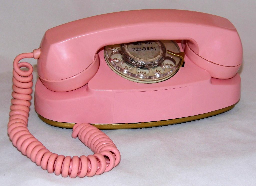 A pink Western Electric Princess rotary telephone with a coiled pink cord