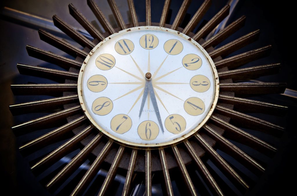 A Westclox wall clock with a cream face, gold numeral discs and a ring of long metal rays