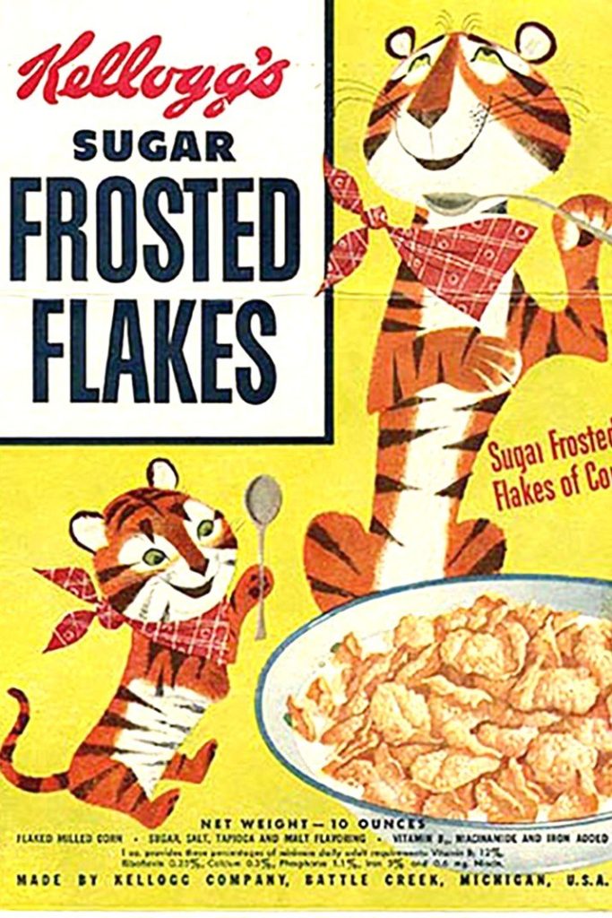 Front of a yellow Kellogg's Sugar Frosted Flakes box with a grinning cartoon Tony the Tiger in a red neckerchief holding a spoon, a cub version of him, and a bowl of flakes