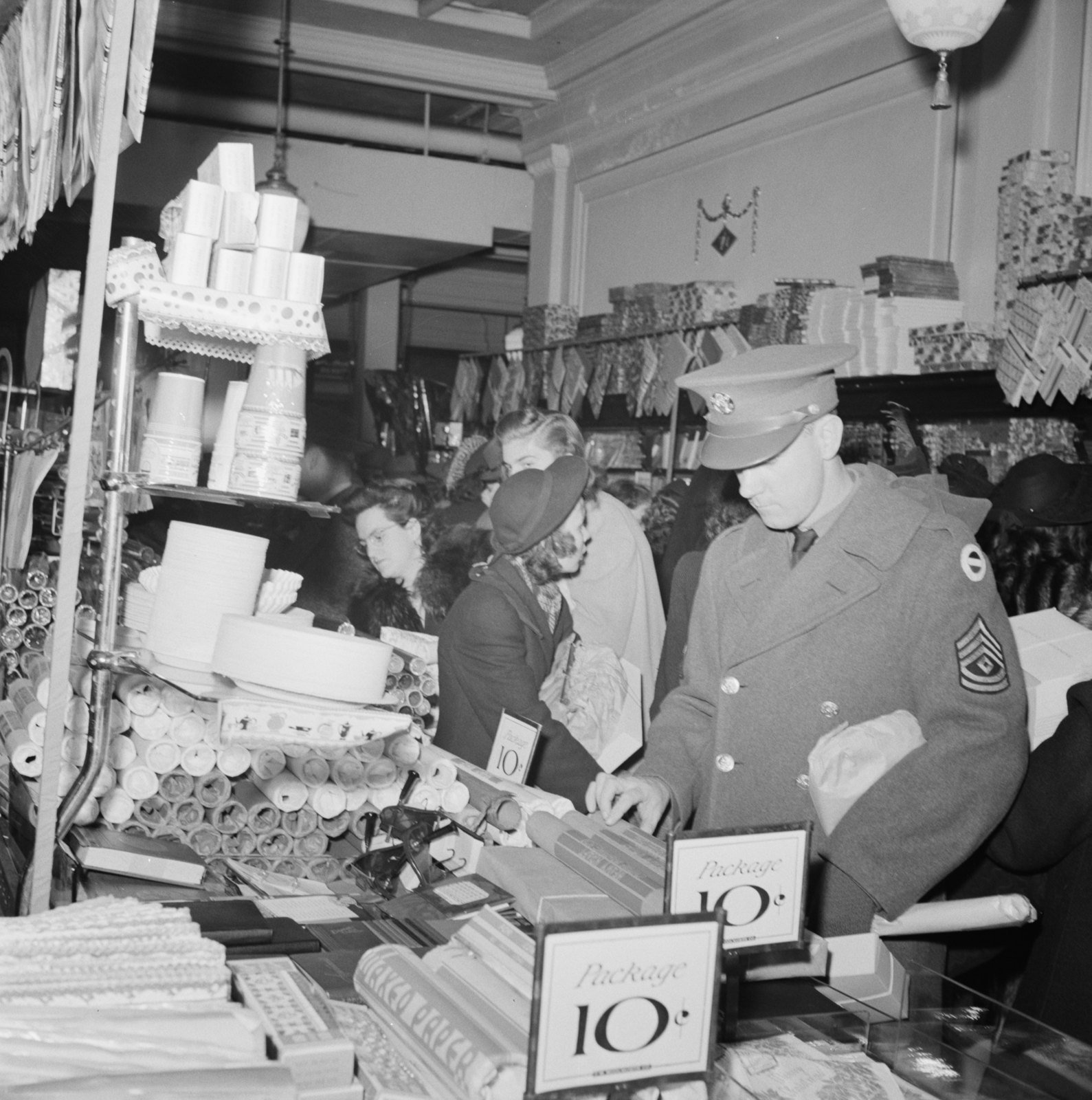 A soldier and other shoppers browse a crowded Woolworth’s counter marked with 10-cent price signs.